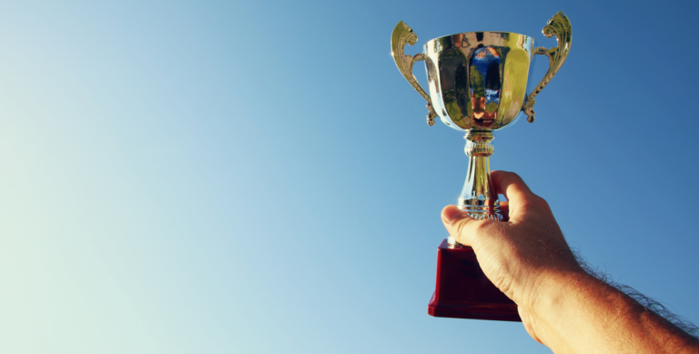 un responsable RSE qui tient une coupe, représentant sa médaille EcoVadis